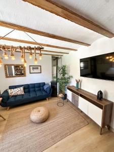 a living room with a blue couch and a tv at Casa Cueva Luna in Orce