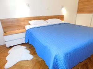 uma cama azul com duas toalhas brancas no chão em Modern Apartment Hrenova Street em Ljubljana