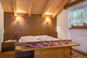 a bedroom with a bed with a wooden wall at Funtnatsch Apartment Schlern in Laion