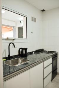 a kitchen counter with a sink and a mirror at La Isabel in Esquel