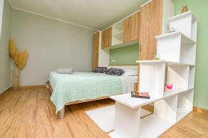 a small bedroom with a bed and shelves at Studio Leon & rent a quad in Mali Lošinj