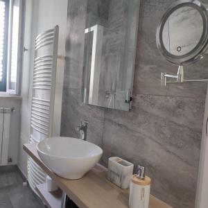 y baño con lavabo blanco y espejo. en Dibbio's house, en Guidonia