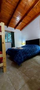 1 dormitorio con 1 cama en una habitación con techos de madera en Departamentos VGB. en Villa General Belgrano