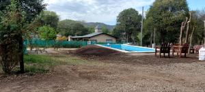 una piscina en un patio con 2 sillas en Departamentos VGB. en Villa General Belgrano