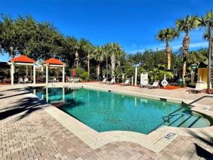 a large swimming pool in a resort with palm trees at Theme Park Paradise! in Kissimmee