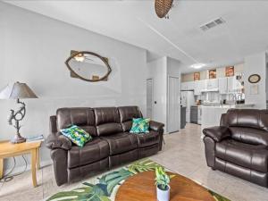 a living room with a leather couch and a table at Theme Park Paradise! in Kissimmee