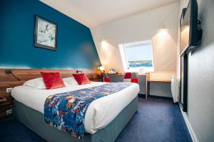 a hotel room with a large bed and a window at Hôtel de France in Camaret-sur-Mer
