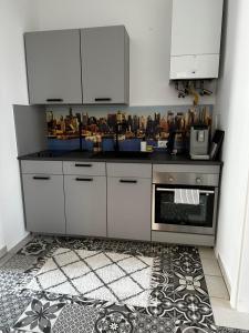 DOWA Apartments Thaliastrasse في فيينا: مطبخ بدولاب بيضاء وموقد