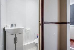 Baño blanco con lavabo y aseo en Cosy 3 BDR Home With Wifi, Parking + Garden, en Tilbury