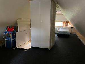 1 dormitorio con 1 cama y armario blanco en Oasis Giethoorn, en Giethoorn