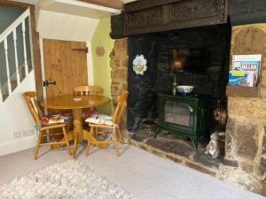 a living room with a table and a stove at Lemon Cottage in Hatherleigh
