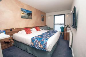 a hotel room with a large bed and a television at Hôtel de France in Camaret-sur-Mer