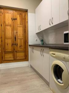a kitchen with a washing machine and a wooden door at El Alma de Granada 2 in Granada