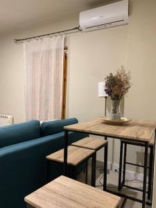 - un salon avec une table et un canapé bleu dans l'établissement El Alma de Granada 2, à Grenade