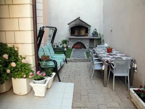 un patio con tavolo, sedie e camino di Apartments Villa Katarina a Makarska