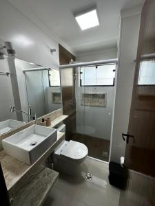 a bathroom with a sink and a toilet and a shower at LINDO APTO ITAGUA (UBATUBA) in Ubatuba