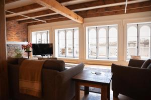 sala de estar con sofás, TV y ventanas en Royal Dalhousie, en Quebec