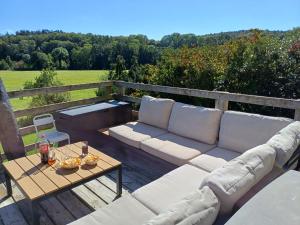 um pátio com um sofá e uma mesa com vista em Maison d'Engon charme nature em Beauraing
