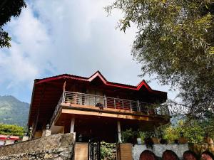 a building with a balcony on top of it at The little nest Home Stay in Bhīm Tāl