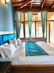 a bedroom with a large bed with a blue headboard at The little nest Home Stay in Bhīm Tāl