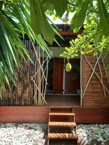 a house with a wooden porch with two wooden steps at Bungalow atypique Ti Bambou à 500m de la plage in Sainte-Anne