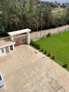 a bench sitting on a patio with a lawn at Koselig California in Nanyuki