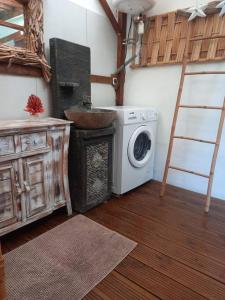 a kitchen with a washing machine and a sink at Bungalow atypique Ti Bambou à 500m de la plage in Sainte-Anne