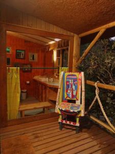 einen Schaukelstuhl auf einer Veranda eines Hauses in der Unterkunft Arte Vitral Lodge - 4camas- aislada- terrazas -vista - piscina-sauna in Guayacán