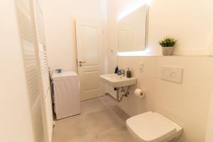 a white bathroom with a toilet and a sink at *NEU* 2 Personen, WLAN, Balkon in Pirna