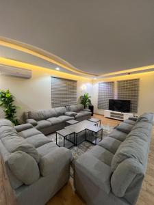 una gran sala de estar con sofás y TV. en شاليهات وايت هافن - ابها, en Khamis Mushayt