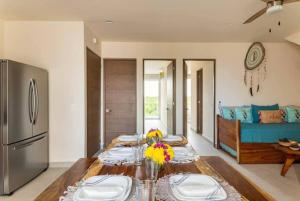 een woonkamer met een tafel met borden erop bij Santamar Penthouse G 306 in Akumal