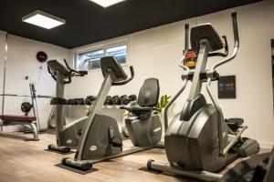 a gym with treadmills and elliptical machines at The Originals City, Hôtel Rive Droite, Albi "Quartier Madeleine" in Albi