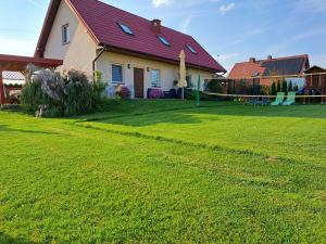 a house with a yard with a green lawn at Agroturystyka Gazdówka in Zakliczyn