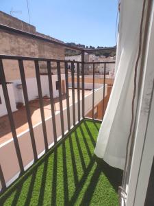 a balcony with green grass and a fence at Luminoso apartamento en centro del pueblo con Wifi y A' A' in Sagunto