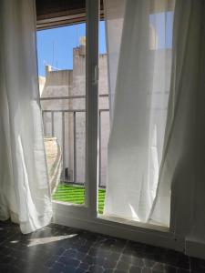an open window with white curtains and a balcony at Luminoso apartamento en centro del pueblo con Wifi y A' A' in Sagunto