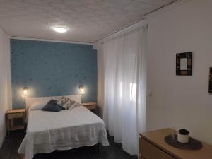 - une chambre avec un lit et un mur bleu dans l'établissement Luminoso apartamento en centro del pueblo con Wifi y A' A', à Sagonte