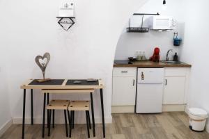 een kleine keuken met een tafel en een aanrecht bij Amores Loft Rural in Alcalá de los Gazules