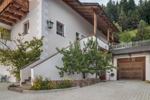 a white house with a wooden door and a courtyard at Funtnatsch Apartment Schlern in Laion