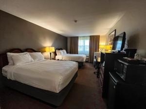 um quarto de hotel com duas camas e uma televisão de ecrã plano em Harbor Winds Hotel em Sheboygan