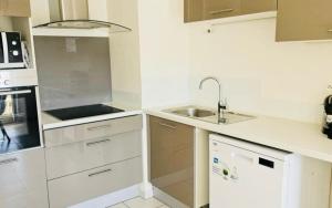 a small kitchen with white cabinets and a sink at Le palais Omnisport grand apt avec terrasse by Weekome in Marseille