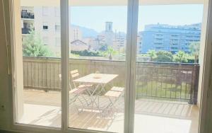 a balcony with a table and a view of a city at Le palais Omnisport grand apt avec terrasse by Weekome in Marseille