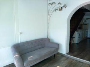 eine Couch in einem Wohnzimmer mit Flur in der Unterkunft LA MAISON DU LAC climatisée et WiFi gd F3 in Port-la-Nouvelle