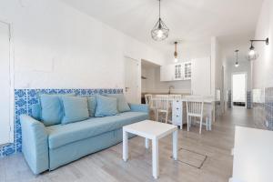 a living room with a blue couch and a table at T2 Praia Baleal in Baleal