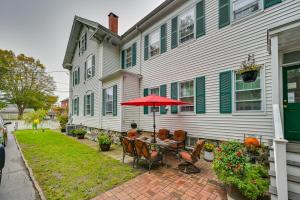 a patio with a table with an umbrella in front of a house at Charming Danvers Studio 5 Mi to Salem! in Danvers