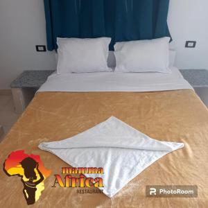 a bed with a comforter on top of it at Mama Africa Apts & Studios in Luxor