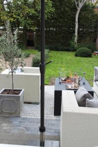 un patio con 2 sofás y una mesa con un árbol en Casa della Nonna, en Diest