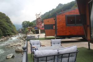 a view of a river with two chairs and a building at Akasya Tiny House in Ardeşen