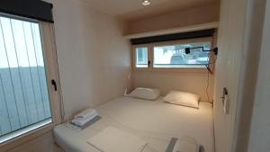 een kleine kamer met een bed en een raam bij BUQEZ VILLAS - VILLA 48 in Drage
