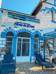 un bâtiment bleu avec deux bancs devant lui dans l'établissement POUSADA AREIA DA PRAIA, à Fortaleza