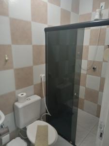 uma casa de banho com um WC e uma cabina de duche em vidro. em POUSADA AREIA DA PRAIA em Fortaleza